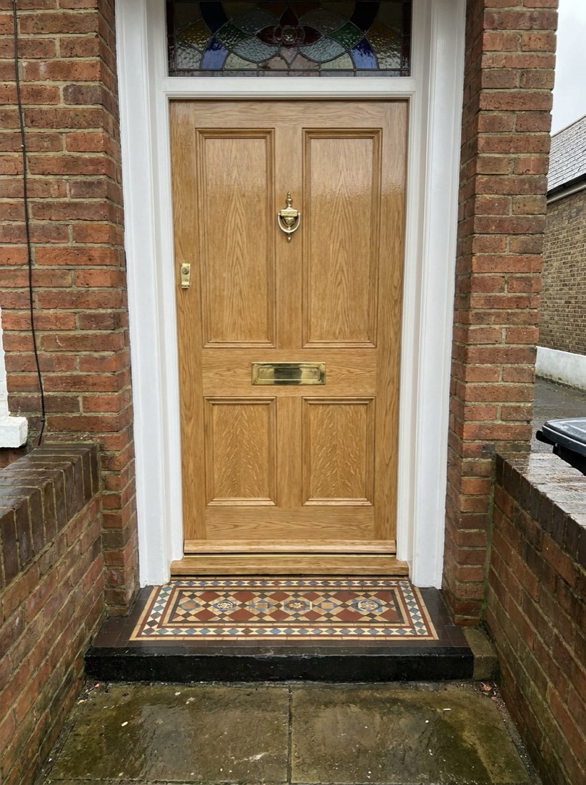 Victorian front door hand-grained to look like light oak, with brass letterbox and tiled step